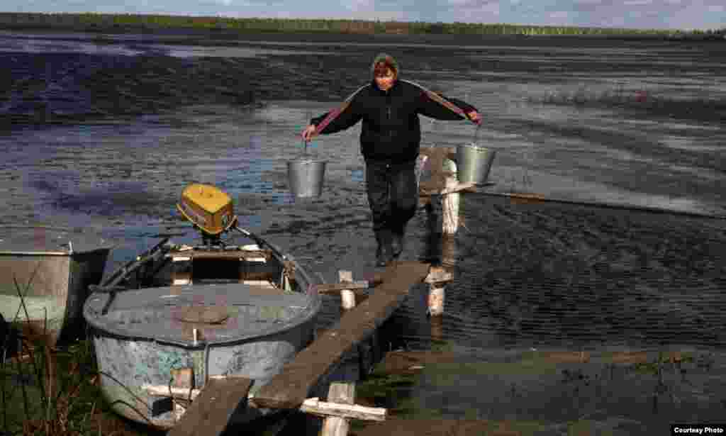 A Tatar woman carries water in the Tyumen region of Russia.