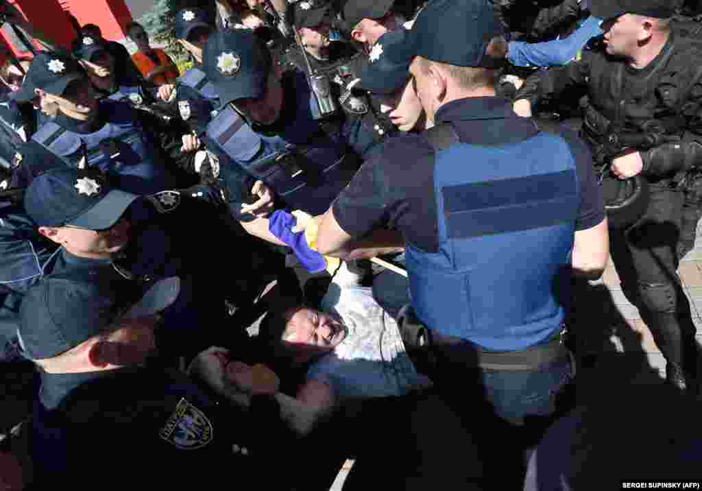 Ukrainian police arrest a protester during a gay-pride parade in Kyiv on June 12, 2016.