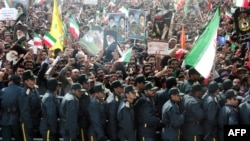 Security forces stand in front of a crowd during a ceremony marking the 31st anniversary of the 1979 Islamic Revolution in Tehran.