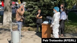 Митинг өтетін жерге келген адамдардың дене қызуын тексеріп тұрған медицина қызметкерлері. Алматы, 13 қыркүйек 2020 жыл.