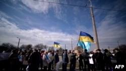 Демонстранти, які виступають за цілісність України, несуть українські та кримськотатарські прапори під час ходи вулицями Сімферополя, 14 березня 2014 року