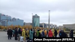 Борышкерлер Бәйтеректен министрлер үйіне бара жатыр. Астана, 1 қазан 2013 жыл.