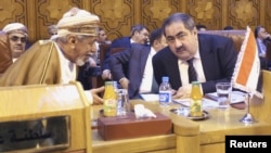 Iraqi Foreign Minister Hoshiyar Zebari (R) talks with an Omani foreign affairs representative at the Arab League foreign ministers' meeting on Syria at the Arab League headquarters in Cairo on November 12.
