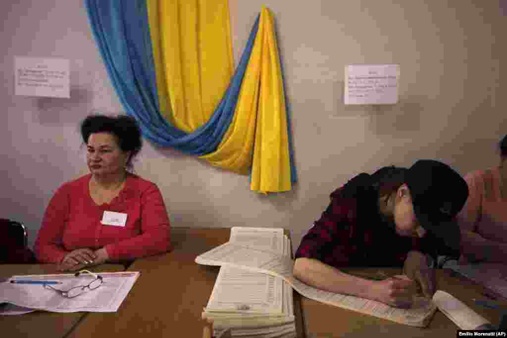 Electoral workers prepare ballots at a polling station. (AP/Emilio Morenatti)