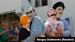 Активисты движения Guy Fawkes, одетые в милицейские формы, проводят акцию в поддержку жертв насилия: "Better dolls than girls"