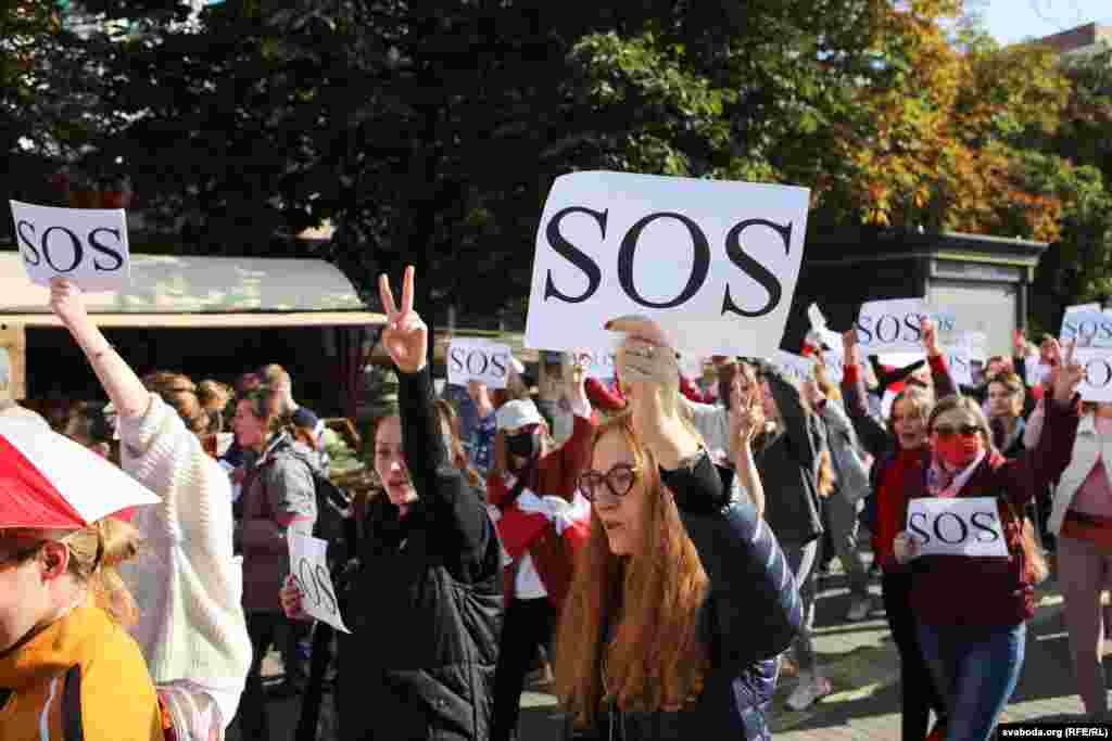 У многих женщин в руках табличка SOS