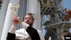 Православный священник благословляет ракету-носитель "Протон" перед выводом на орбиту первого казахстанского спутника связи KazSat. Иллюстративное фото.