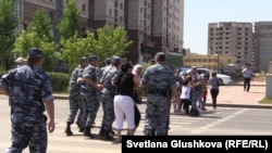 Полицейские уводят жителей комплекса "Махаббат", которые вышли на протест и пытались перекрыть дорогу. Астана, 16 июля 2015 года.
