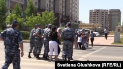 Полицейские уводят жителей проблемного жилого комплекса, которые пытались перекрыть дорогу. Астана, 16 июля 2015 года.