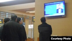 Illýustrasiýa suraty. Aşgabadyň halkara aeroportunda telewizora tomaşa edýän adamlar.