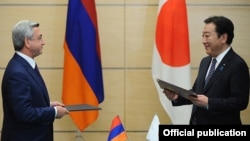 Japan - Prime Minister Yoshihiko Noda (R) and Armenian President Serzh Sarkisian exchange copies of a joint statement signed after their talks in Tokyo, 6Jun2012.