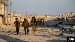 Turkish-backed Syrian rebels walk in the northwestern border town of Al-Bab after they fully captured it from IS militants on February 23.