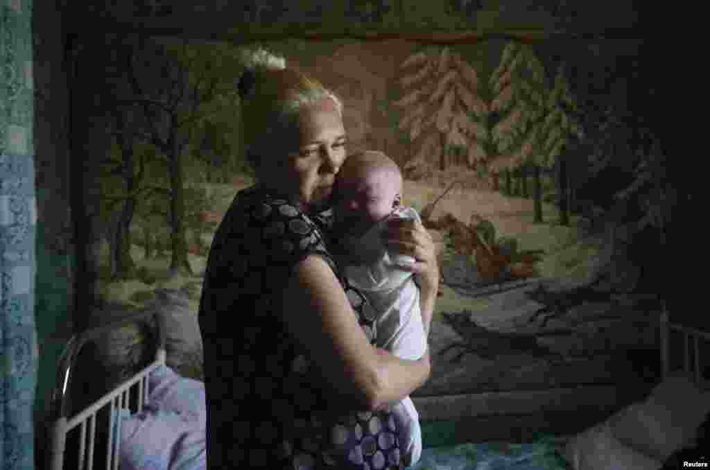 A mother and child who have fled from fighting in Slovyansk stand in their temporary accommodation in the eastern town of Nyzhnya Krynka on June 4.