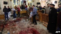 Egypt -- WARNING: Graphic -- People look at the aftermath following a bomb blast which struck worshipers gathering to celebrate Palm Sunday at the Mar Girgis Coptic Church in the Nile Delta City of Tanta, 120 kilometers north of Cairo, 09April2017