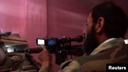 Сирийский повстанец не только стреляет, но и снимает происходящее на видео. Дейр-эз-Зор, 12 июня 2013 г. 