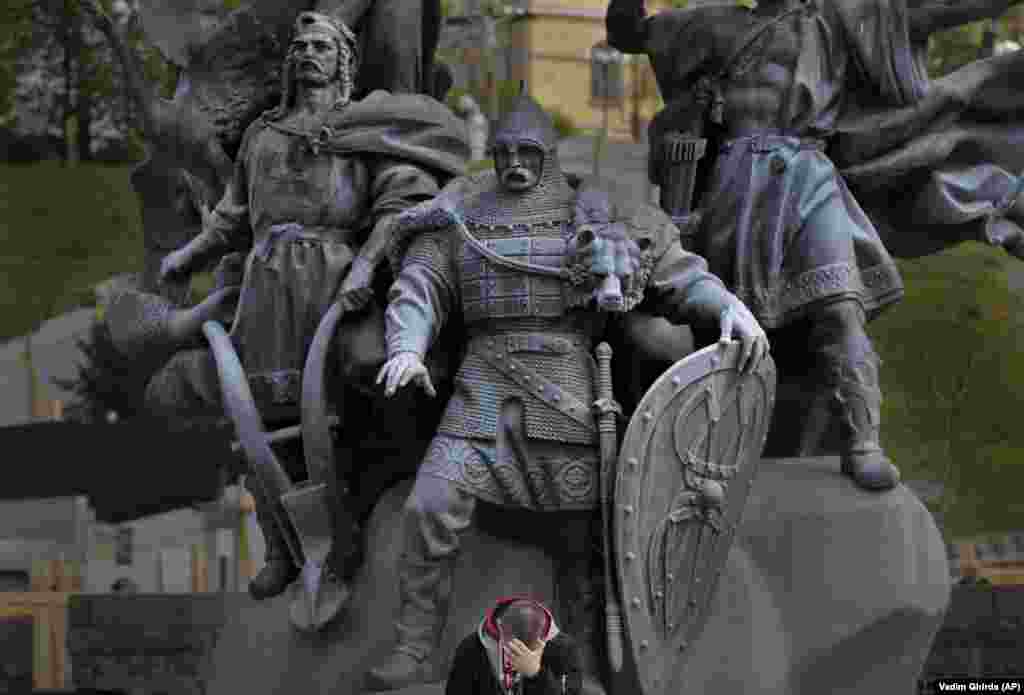 A man sits by the Kyiv Founders monument on Independence Square in Kyiv.&nbsp;(AP/Vadim Ghirda)