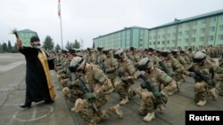 Священник благословляет военнослужащих на военной базе в Вазиани близ Тбилиси перед отъездом в Афганистан, 16 декабря 2014 года