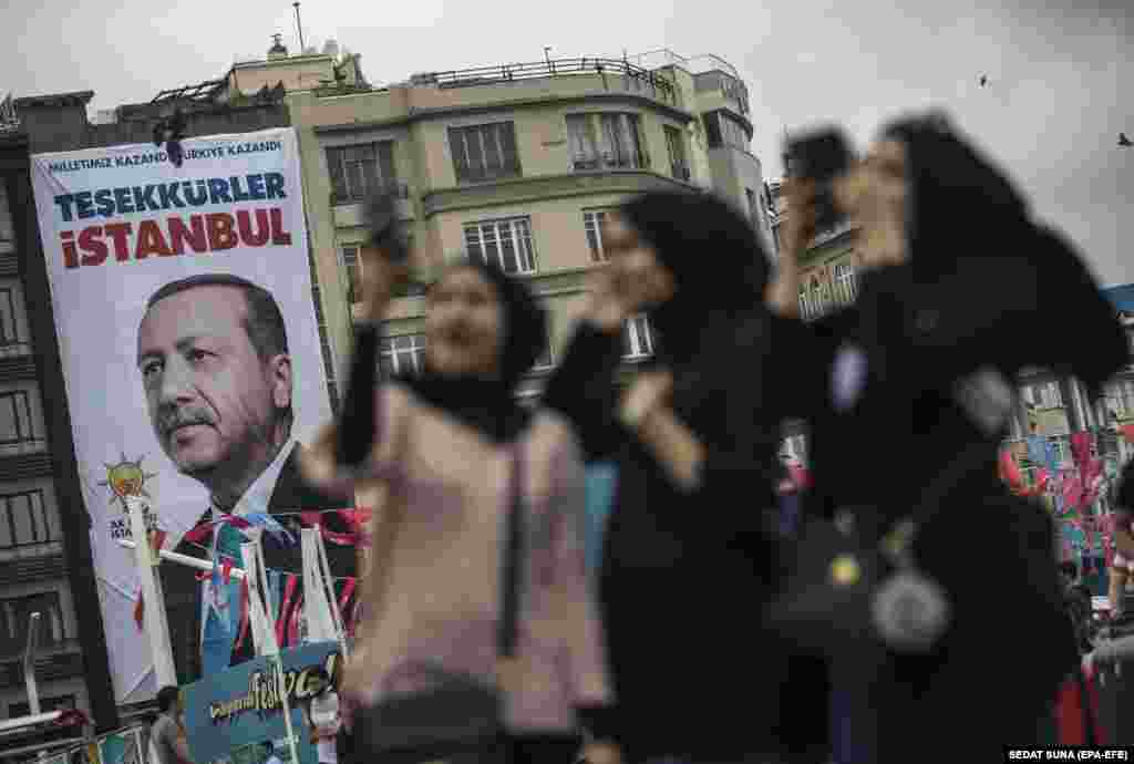 Muslim tourists pose in front of a poster of Turkish President Recep Tayyip Erdogan which reads, &quot;Thank you, Istanbul,&quot; on Taksim Square on June 26. (epa-EFE/Sedat Suna)