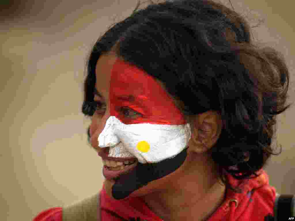 An antigovernment protester, her face painted in the colors of the national flag, stands in Tahrir Square on February 4.