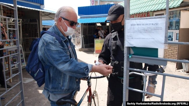 Посетителю рынка измеряют температуру