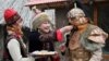 FILE: A woman (L) dressed in national costume offers traditional local dishes during Norouz celebrations in Bishkek.