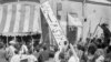 A crowd of demonstrators tear down the Iran Party's sign from the front of the headquarters in Tehran on August 19, 1953, during the pre-Shah riot that swept through the capital and ousted Prime Minister Mohammad Mossadegh.