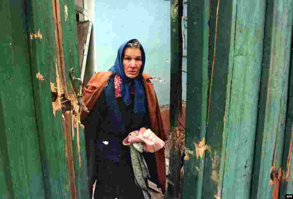 An elderly woman leaving her home during a Russian artillery bombardment. Many ethnic Chechens are able to shelter with relatives in outlying villages. For some of the recently settled ethnic Russians in Grozny, however, there is nowhere to flee.&nbsp;