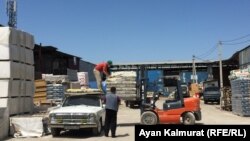 Жүкші жігіт тасымал қызметімен айналысатын Ерланның көлігіне зат тиеп жатыр. Алматы, 3 маусым 2020 жыл.