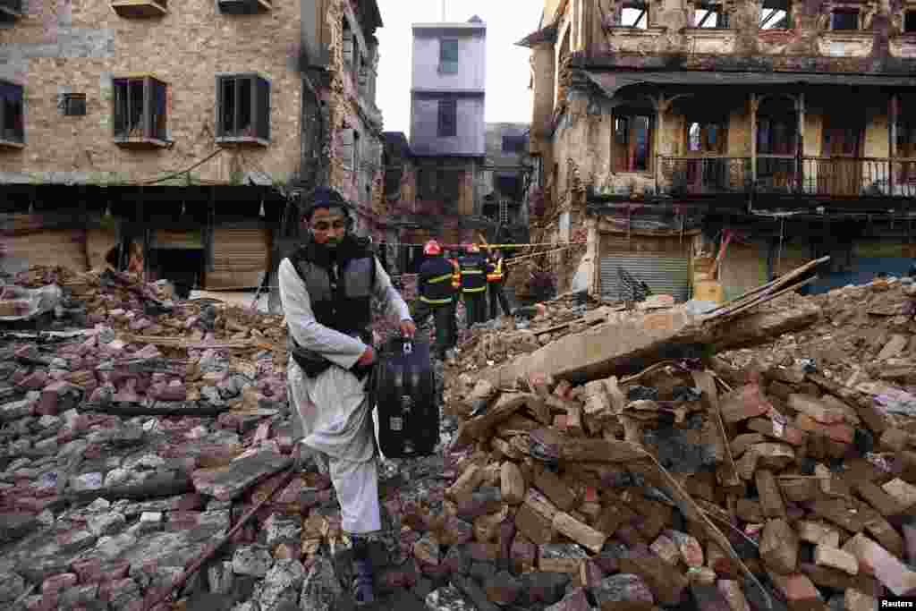 A man carries belongings recovered three days later from a building that burned down during sectarian clashes in Rawalpindi on November 15.