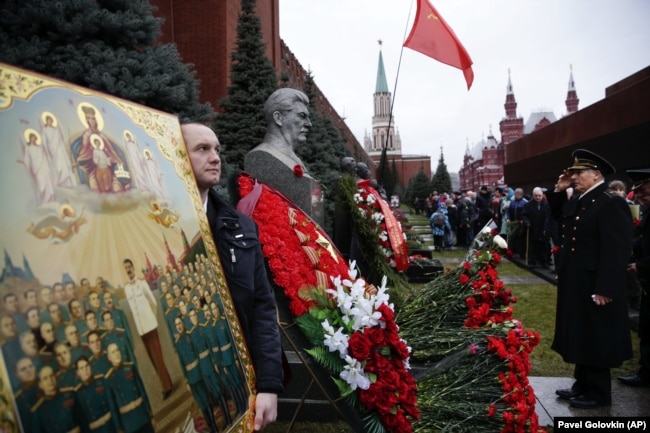 Відзначення дня народження Йосипа Сталіна на його могилі біля Кремлівської стіни на Червоній площі. На фотографії ікона із зображенням радянського диктатора. Москва, 21 грудня 2015 року