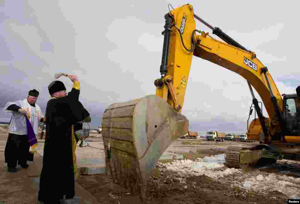 Un preot ortodox și unul catolic sfințesc un excavator la șantierul centralei nucleare de la Ostroveț, 1.02.2013.