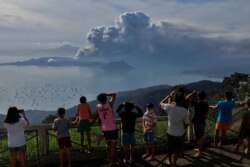 Filipinci gledaju erupciju Tala s bezbedne udaljenosti u gradu Tagajtaj, na oko šest kilometara od Tala, 13. januara.