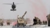 U.S. troops assess the damage to an armored vehicle belonging to the NATO-led military coalition after a suicide attack in Kandahar Province on August 2.