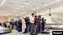 ABŞ, Dallas aeroportynda ýüklerine garaşýan adamlar namaza durýar.Dallas, 29-njy ýanwar, 2017