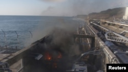 Fire and smoke in a building near Reactor No. 4 at Fukushima on April 12