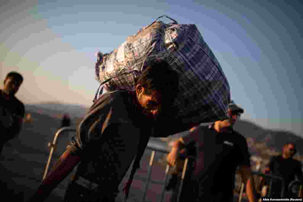 A migrant from Afghanistan carries his belongings as he waits to board a catamaran that will transfer refugees and migrants to the mainland, in Mytilene on the island of Lesbos, Greece. (Reuters/Alkis Konstantinidis)