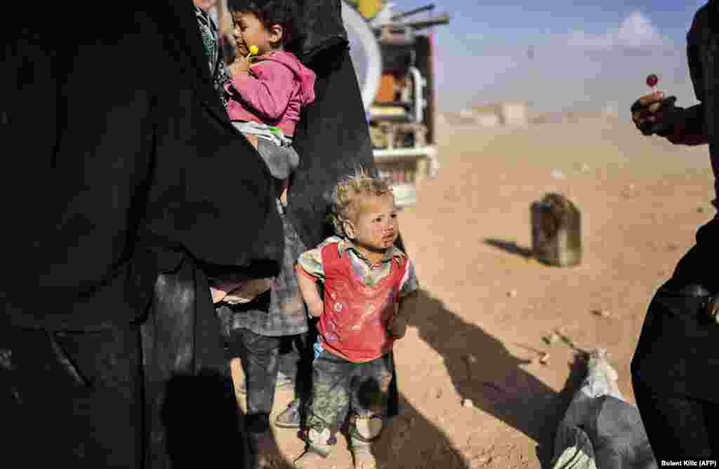 Syrians displaced from the city of Deir al-Zor gather on the outskirts of Raqqa on October 2. Syrian fighters backed by U.S. special operations forces are battling to clear the last remaining Islamic State group extremists holed up in their crumbling stronghold of Raqqa. (AFP/Bulent Kilic)