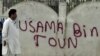 A man walks past a wall with "Osama Bin Town" spray-painted on it in Abbottabad on May 6, days after the U.S. operation to kill Osama bin Laden.