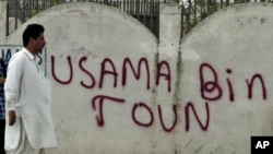A man walks past a wall with "Osama Bin Town" spray-painted on it in Abbottabad on May 6, days after the U.S. operation to kill Osama bin Laden.
