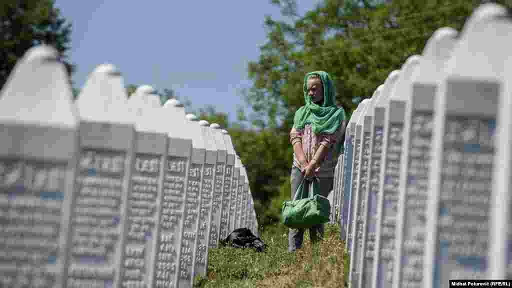 A woman walks among graves at the memorial center, July 11, 2017.