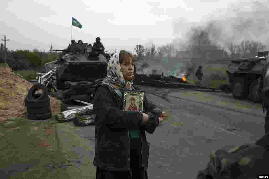 A woman stands with an Orthodox icon at a Ukrainian checkpoint near the eastern town of Slovyansk on May 2. (Reuters/Baz Ratner)