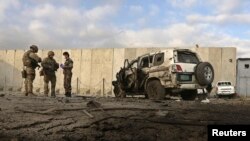 NATO troops investigate at the site of a suicide attack in Kabul, October 13, 2014
