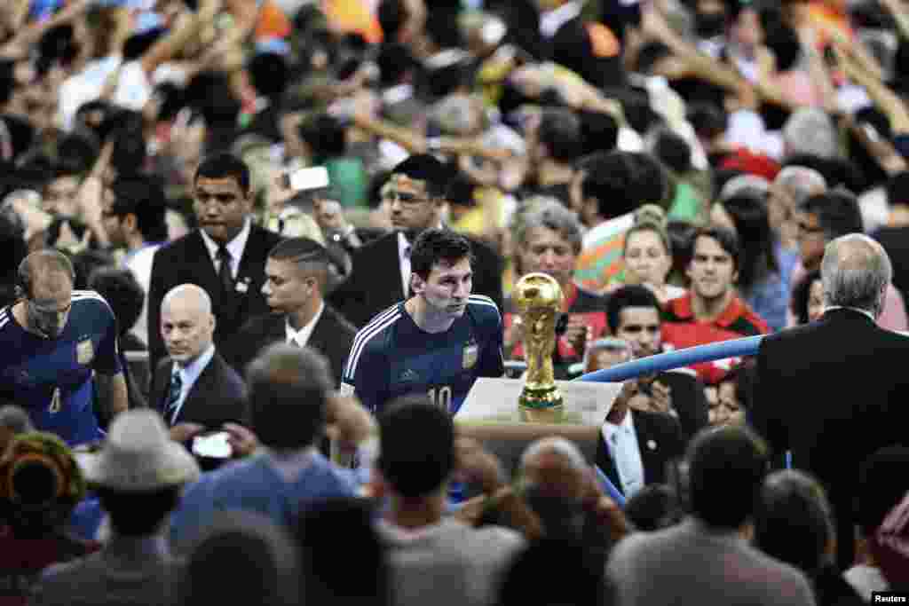 Bao Tailiang, a Chinese photographer of Chengdu Economic Daily, won First Prize in the Sports Category, Singles, with this picture of Argentinian player Lionel Messi facing the World Cup trophy during the final celebrations at Maracana Stadium in Rio de Janeiro, Brazil.