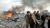 Dim iznad pojasa Gaze nakon vazdušnih napada Izraela dok Palestinci nose jednu od žrtava ovog napada, 27. decembar 2008.