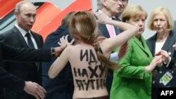 Активистка движения Femen проводит акцию против политики президента России Владимира Путина. Путин - крайний слева. Ганновер, 8 апреля 2013 года.