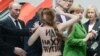 Femen activist Oleksandra Shevchenko described the reaction of Russian President Vladimir Putin (left) as "idiotic astonishment mixed with a smile and a stupid expression on his face." On her back is written "F*** you, Putin."
