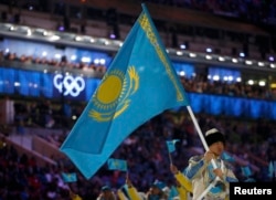 Ердос Ахмадиев несет казахстанский флаг на церемонии открытия зимних Олимпийских игр в Сочи. 7 февраля 2014 года.