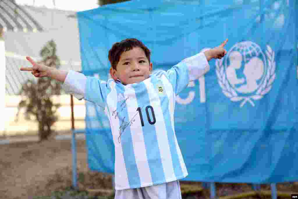 Five-year-old Afghan boy Murtaza Ahmadi, a young fan of FC Barcelona's Argentinian striker Lionel Messi, poses with an Argentinian national soccer team jersey signed by the player himself. (epa/Mahdy Mehraeen)