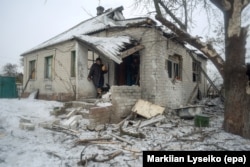 A woman stands at the entrance of her home, damaged by shelling in the eastern city of Avdiyivka on February 2.