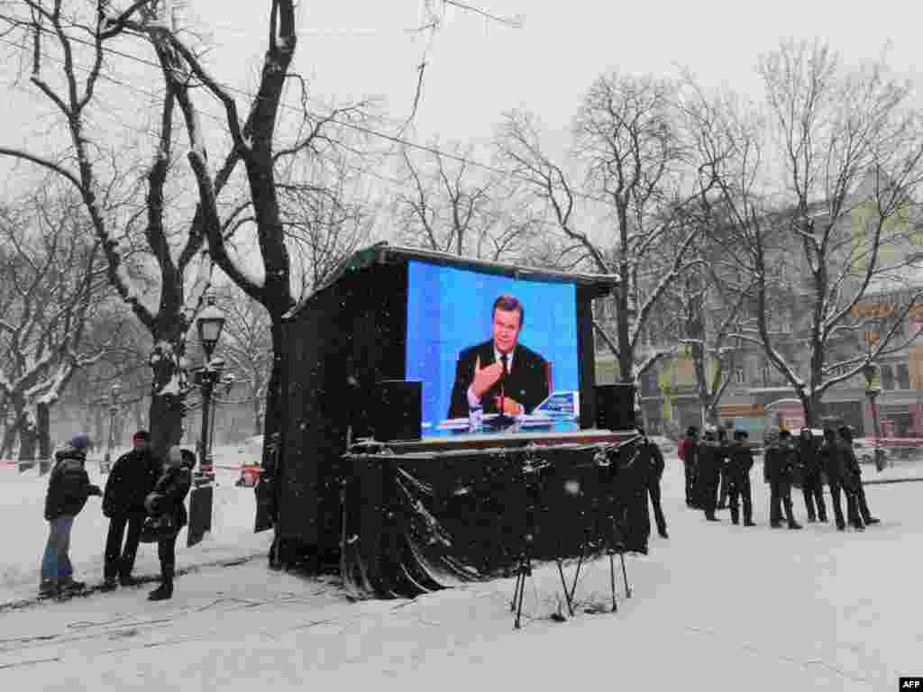 Мінакі на вуліцы Львова не зьвяртаюць увагі на тэлевізійны выступ Віктара Януковіча ў першую гадавіну прэзыдэнцтва, 25 лютага.